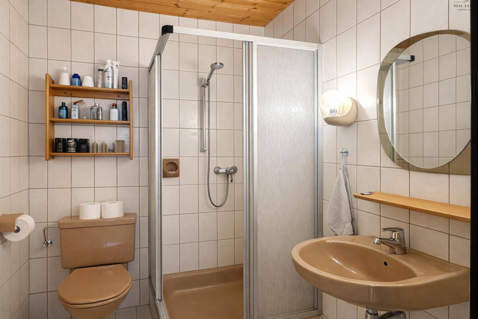 Funktionales Badezimmer mit Dusche, WC und Waschbecken in traditionellem Stil der 80er Jahre.