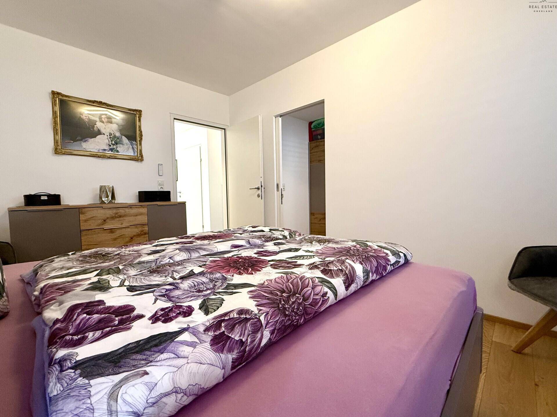 Schlafzimmer mit Holzboden und farbenfroher Bettwäsche, bietet eine ruhige Atmosphäre.