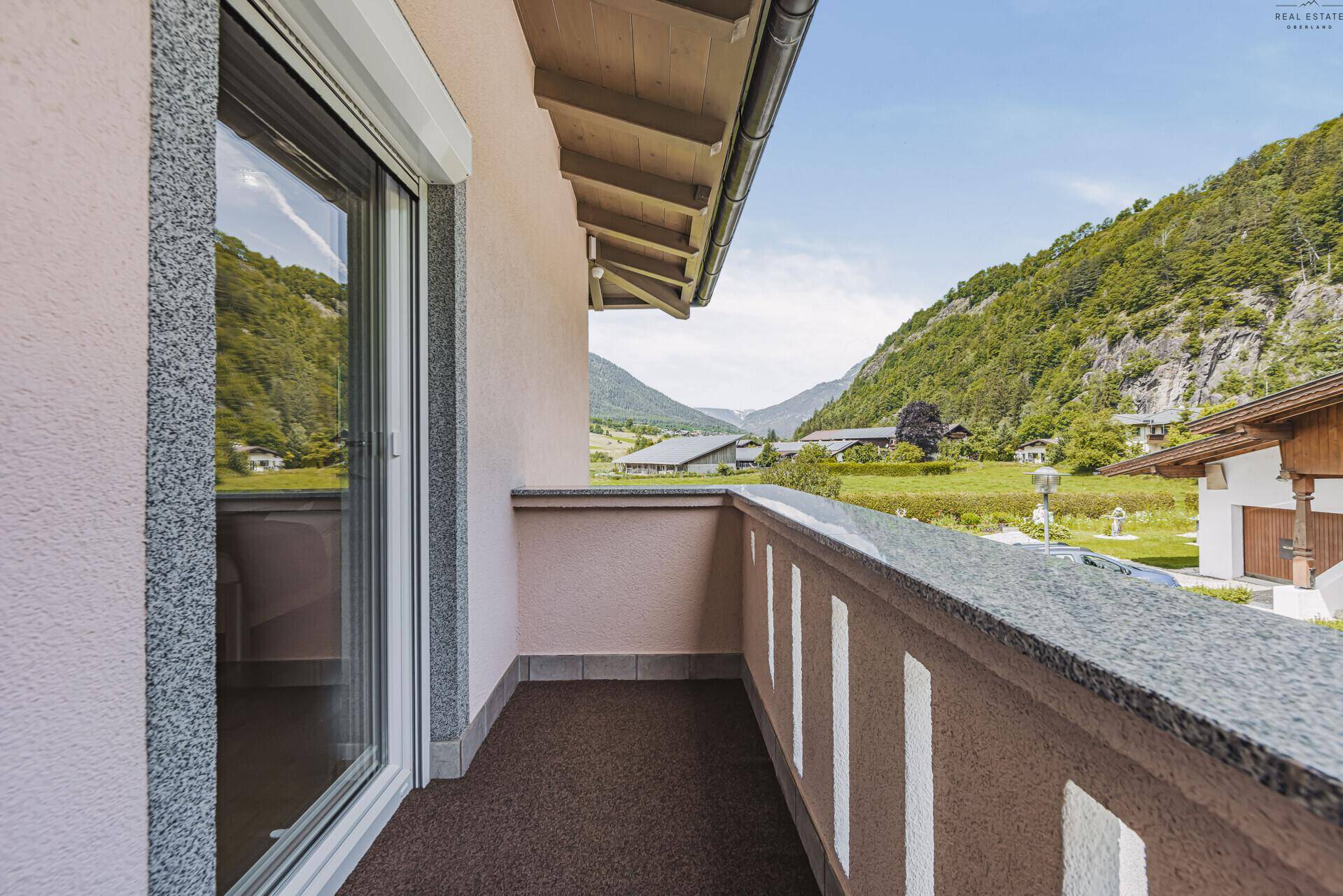 Balkon mit Granitbrüstung und Panoramablick auf die umliegende Bergwelt.