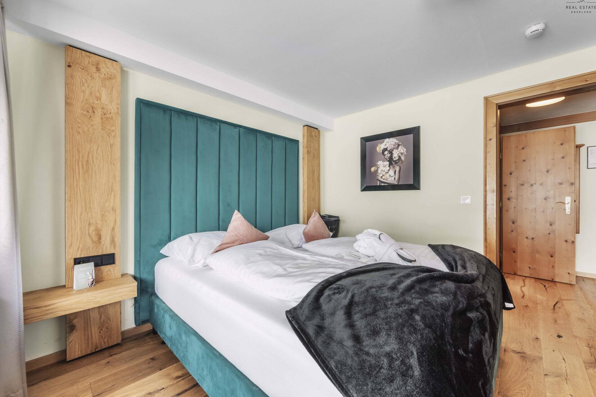 Helles Schlafzimmer mit Doppelbett, Holzfußboden und moderner Einrichtung.
