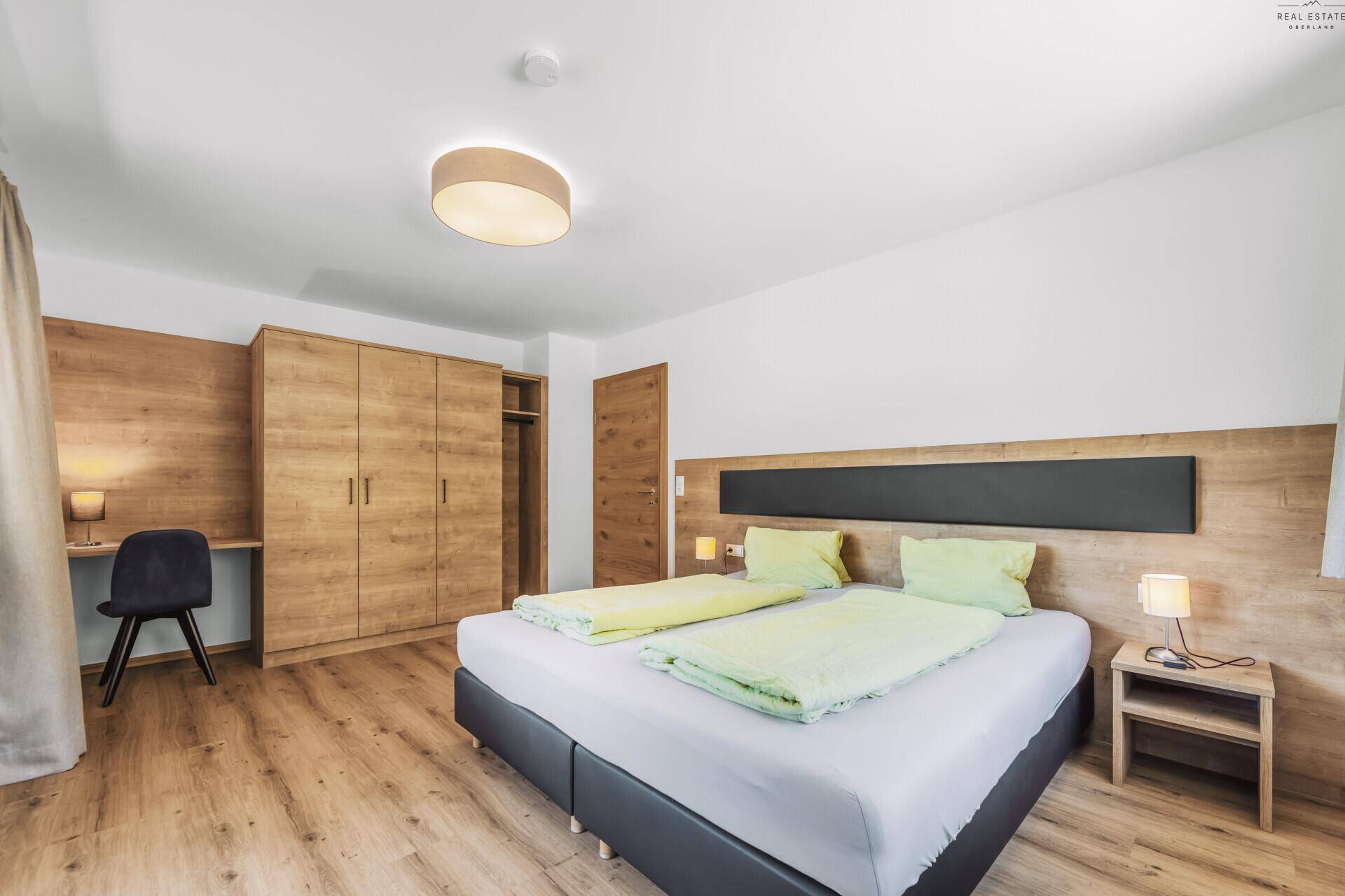 Geräumiges Schlafzimmer mit Doppelbett, Holzboden und großem Kleiderschrank.