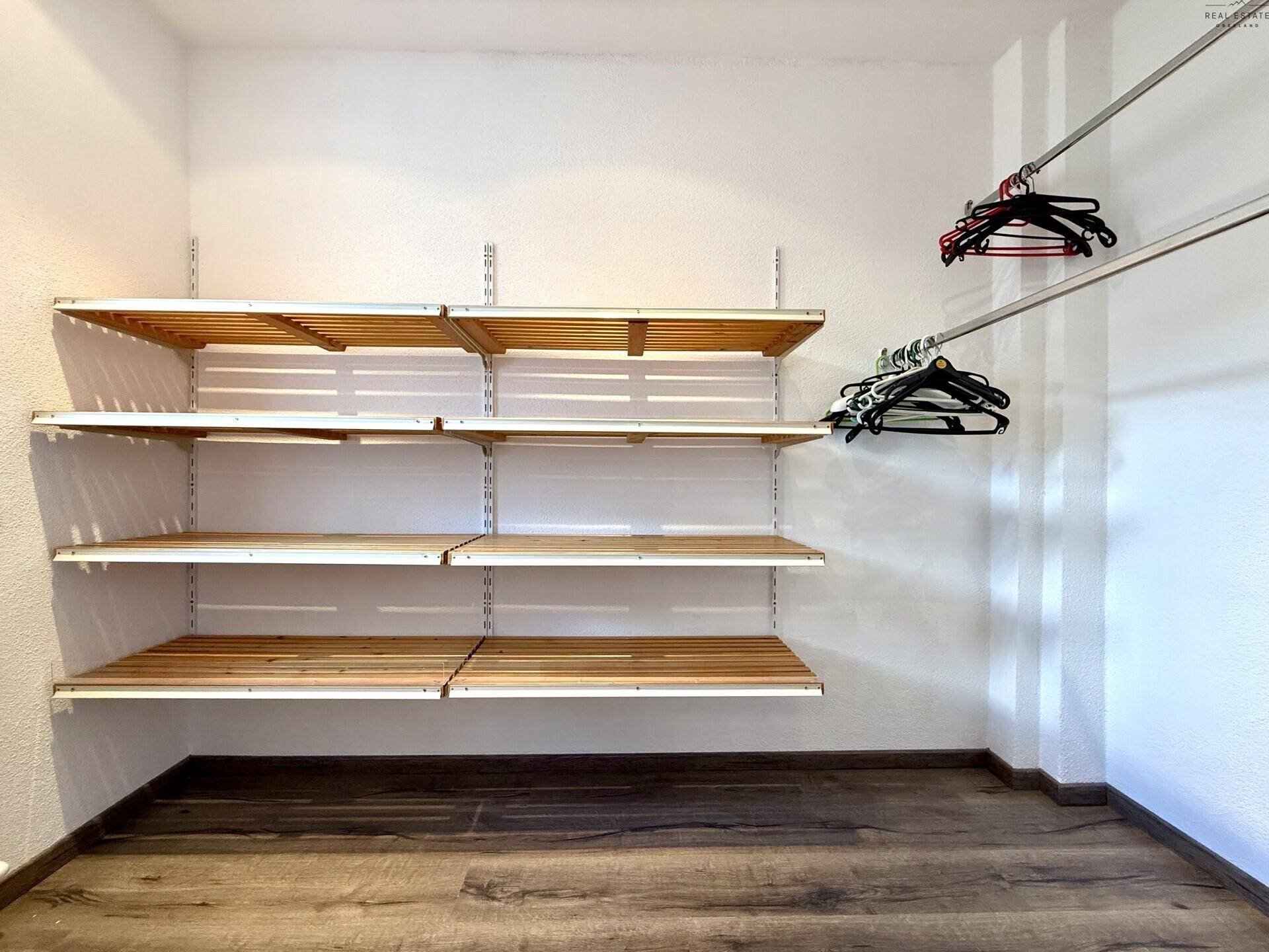 Begehbarer Kleiderschrank mit Regalen und Kleiderstangen für viel Stauraum und Organisation.