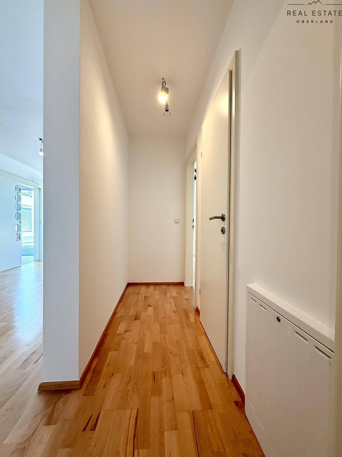 Heller Flur mit Holzboden und Türen zu den angrenzenden Räumen.