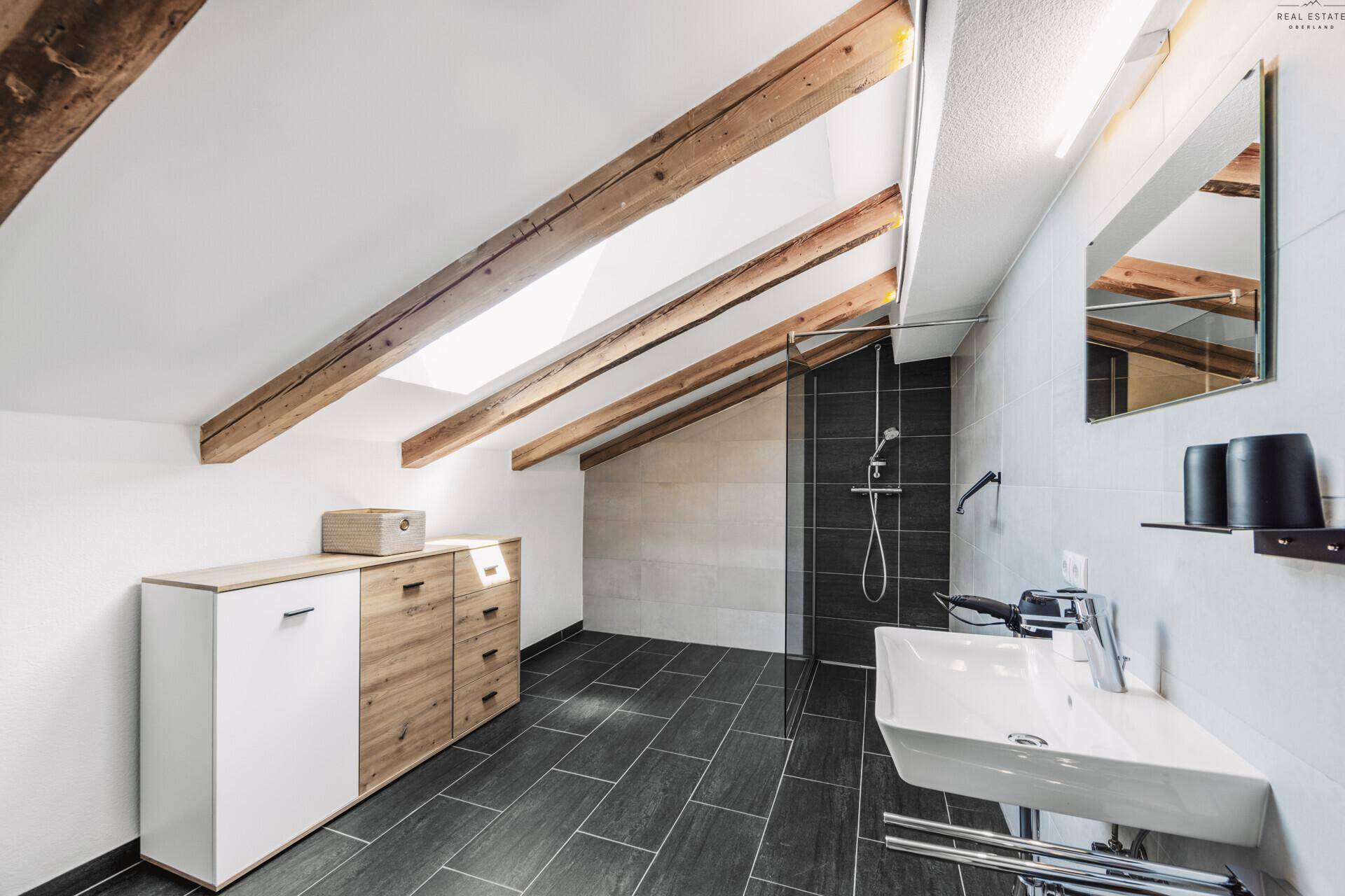Modernes Badezimmer im Dachgeschoss mit begehbarer Dusche, Holzbalken und Dachschräge.