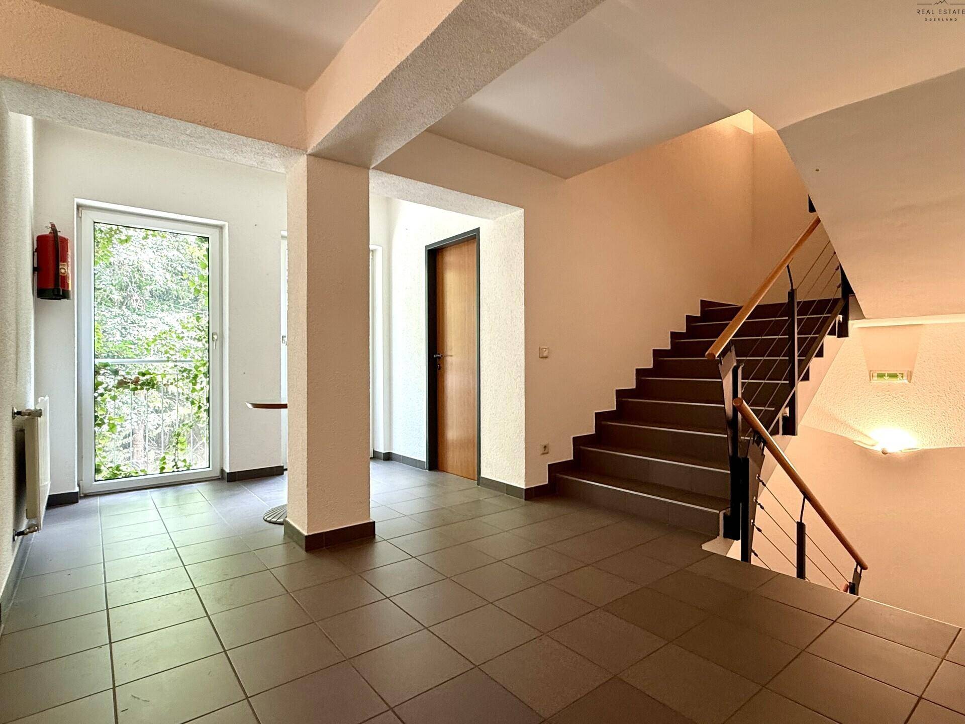 Eingangsbereich mit Treppe, Fliesenboden und Zugang zu einem Außenbereich.