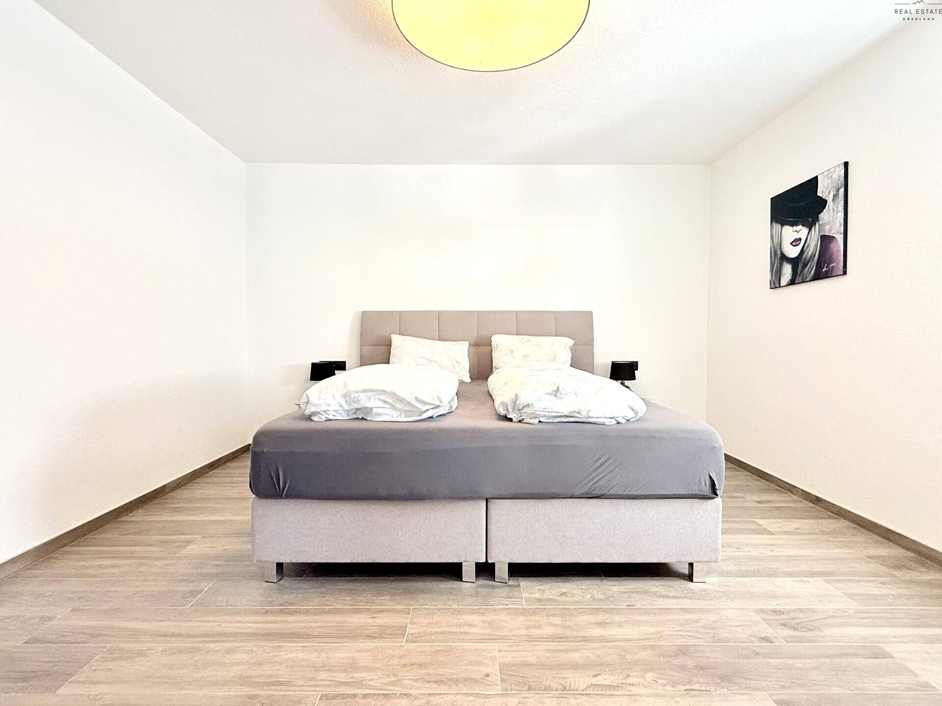 Geräumiges Schlafzimmer mit Doppelbett und modernem Fliesenboden.