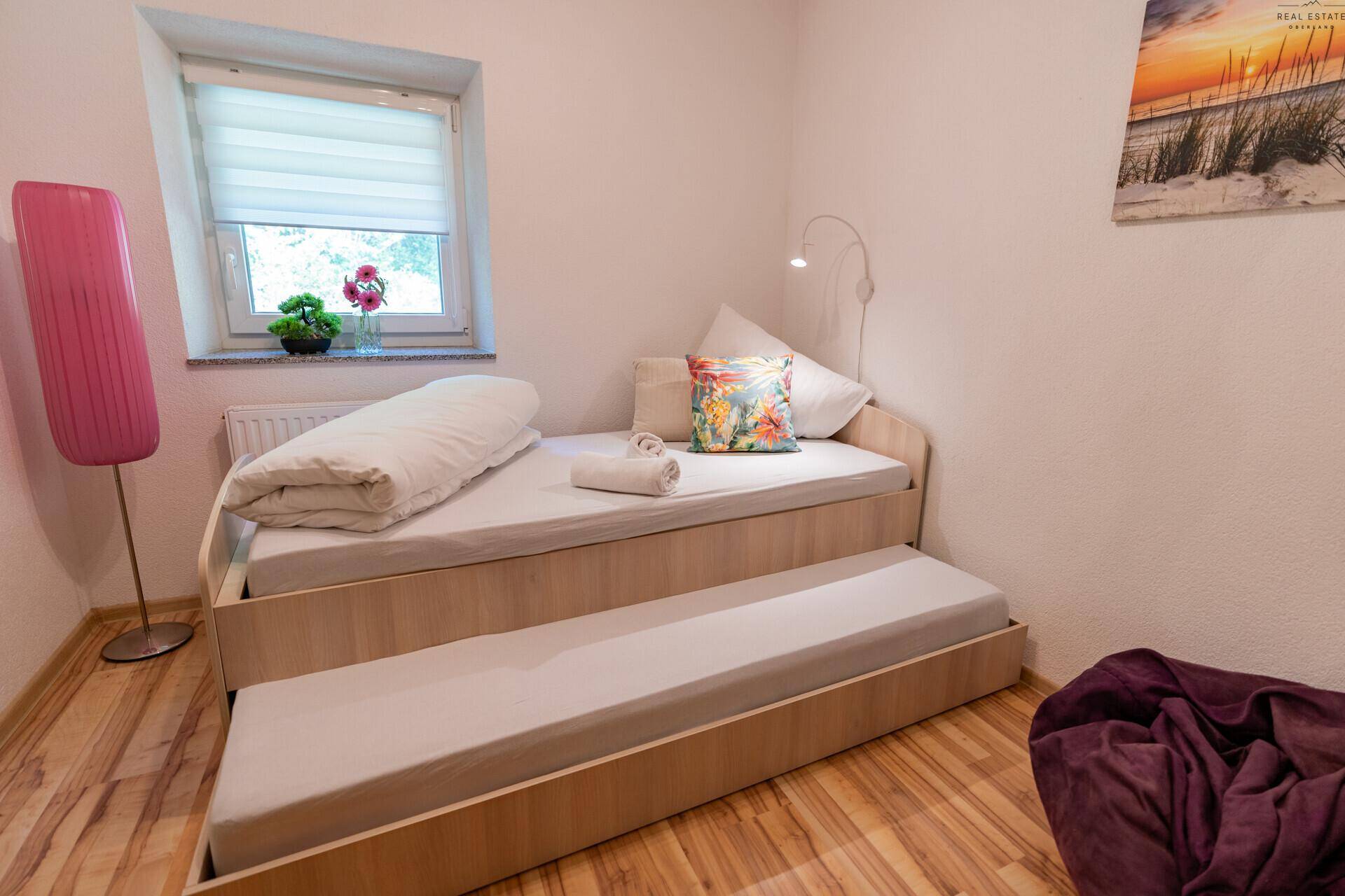 Schlafzimmer mit ausziehbarem Einzelbett, ideal für Gäste oder Kinder.