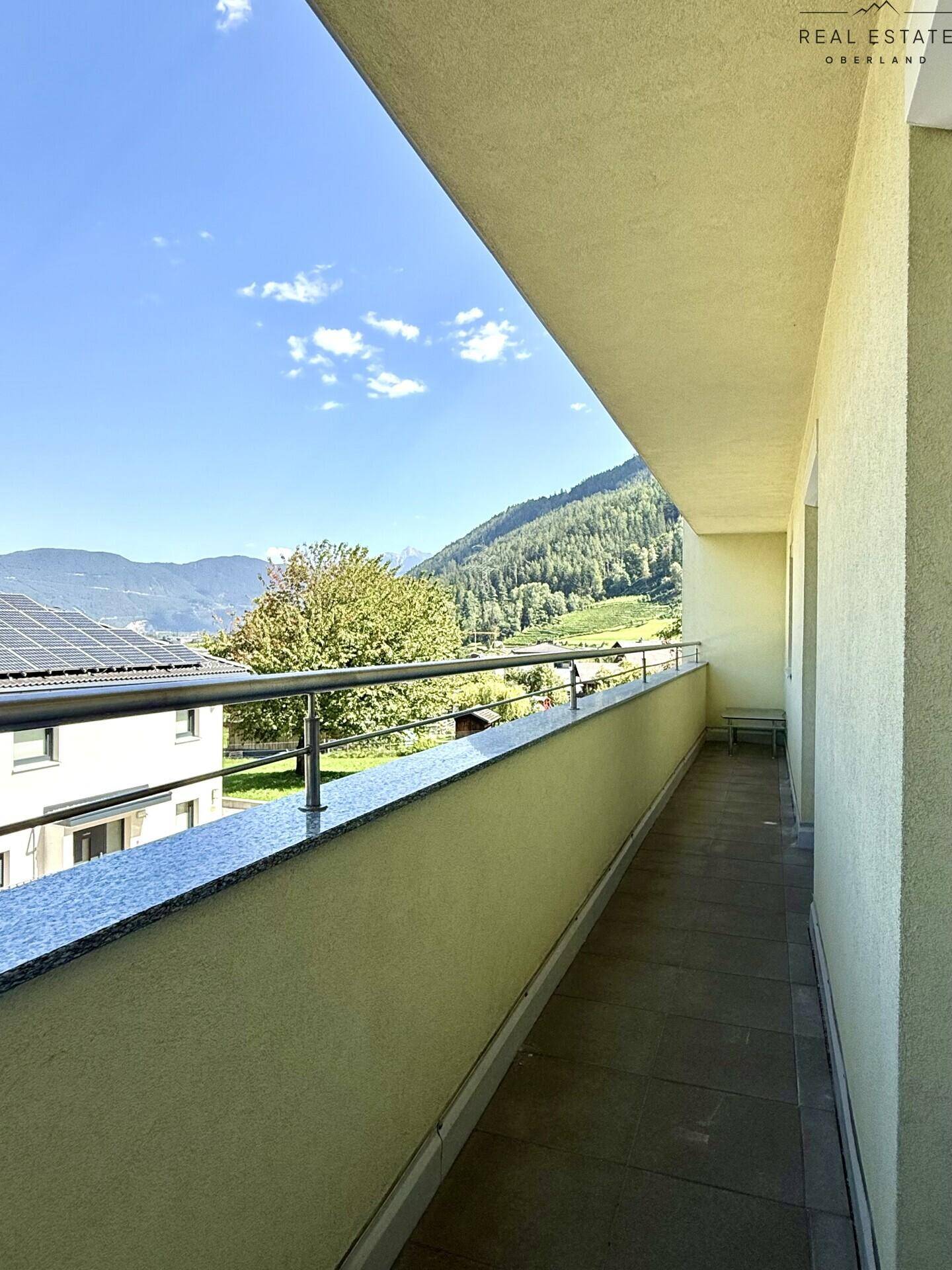 Geräumiger Balkon mit Granitbrüstung und weitem Blick auf die Berge und das Tal.