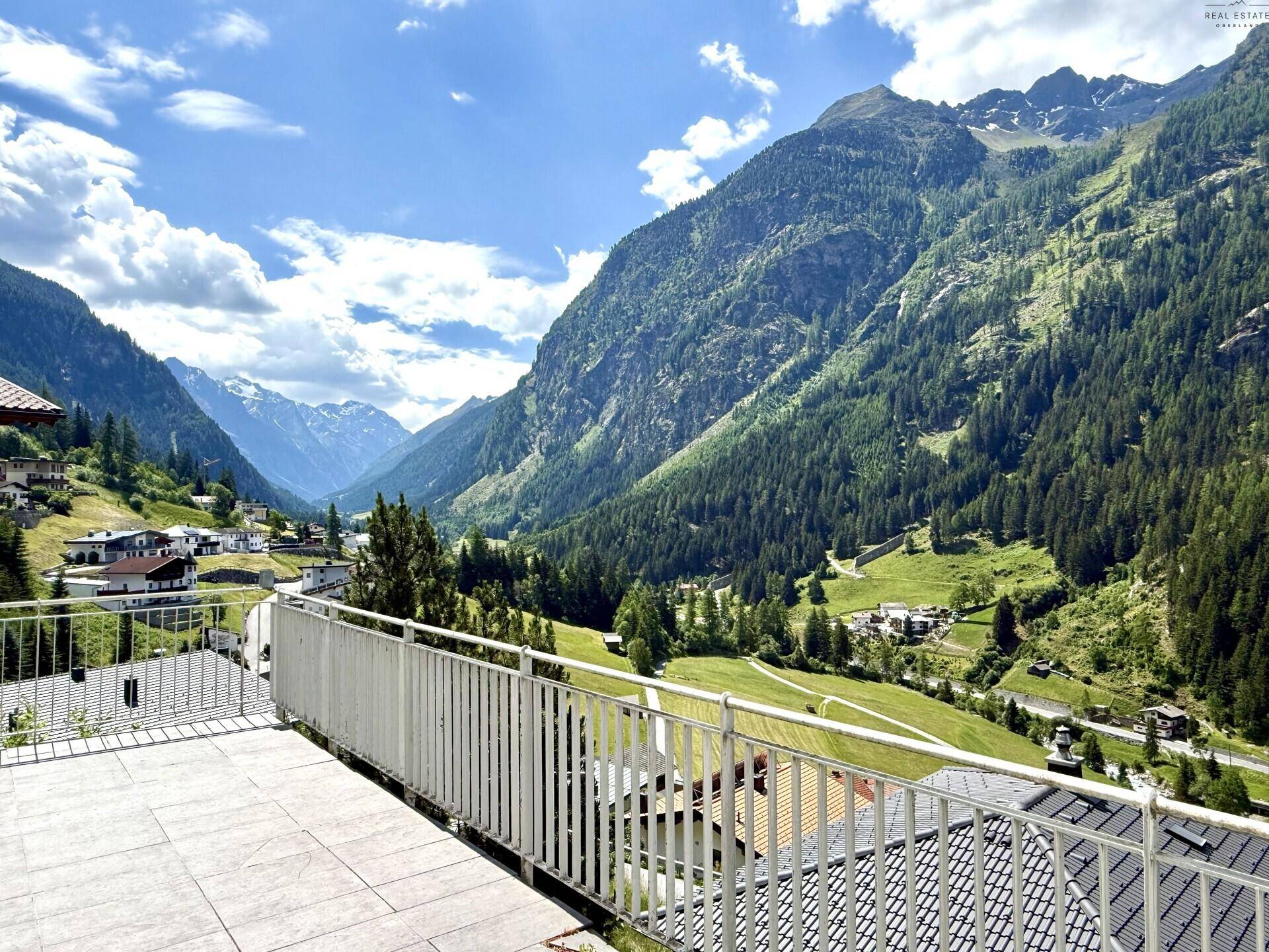 Große Terrasse mit Fliesenboden und atemberaubendem Panoramablick auf die umliegenden Berge und Täler.