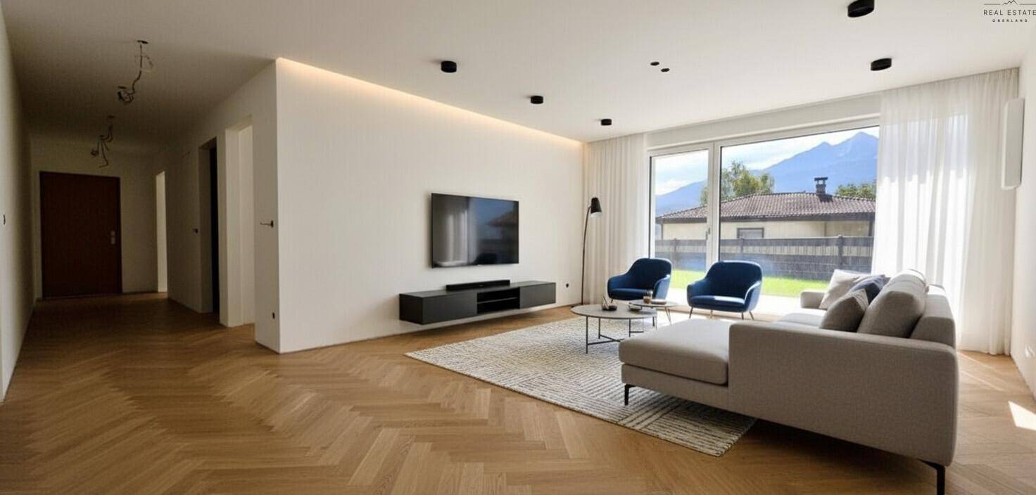 Geräumiges Wohnzimmer mit Holzboden, großen Fenstern und Bergblick.