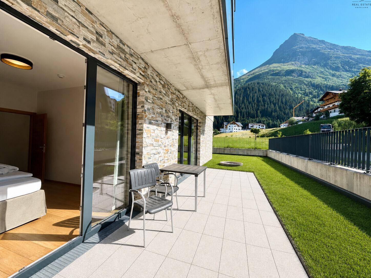 Geräumige Terrasse mit Sitzgelegenheiten und weitem Blick auf die beeindruckende Bergwelt.