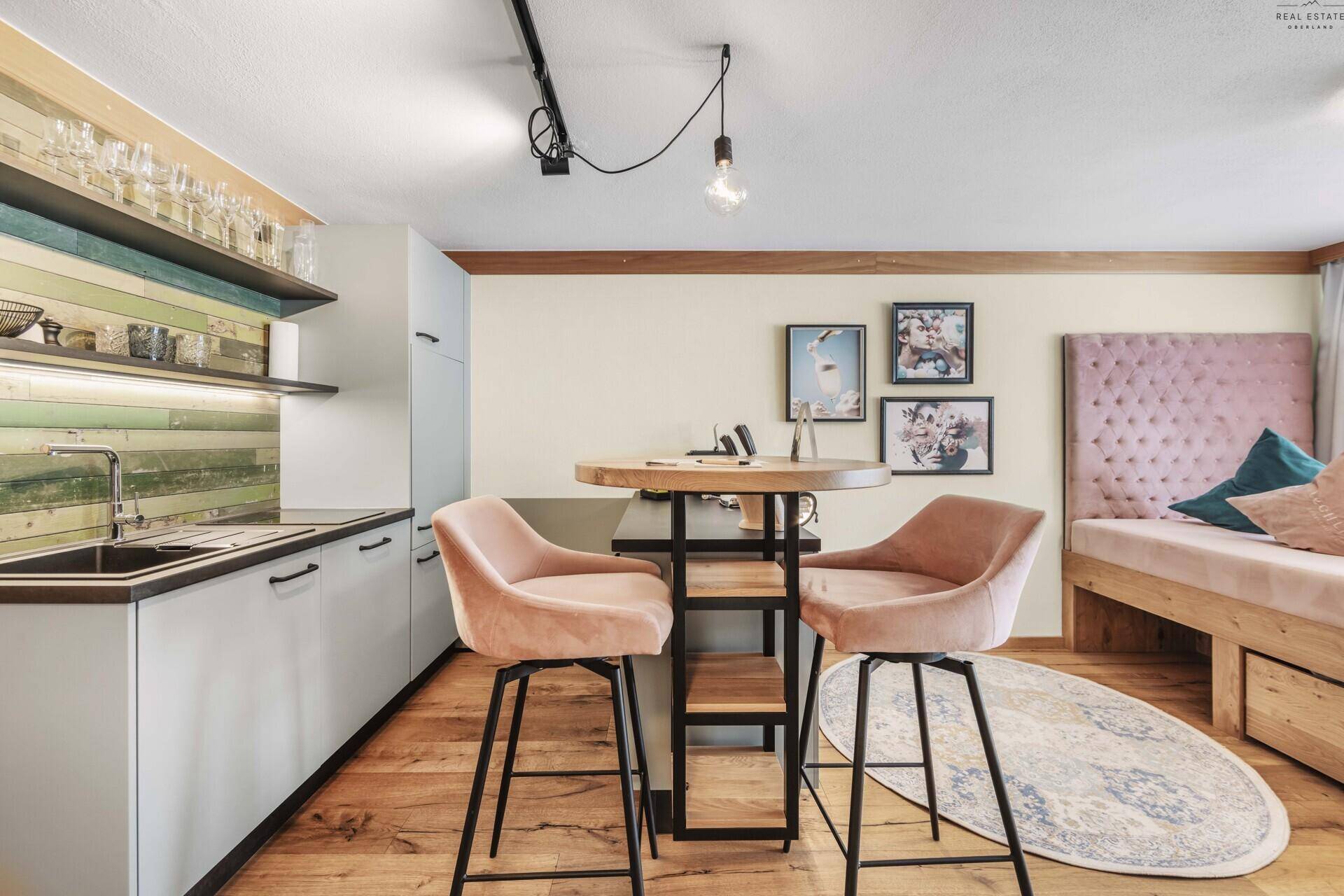 Helles Studio-Apartment mit Küchenzeile, Bartisch und bequemen Barhockern.