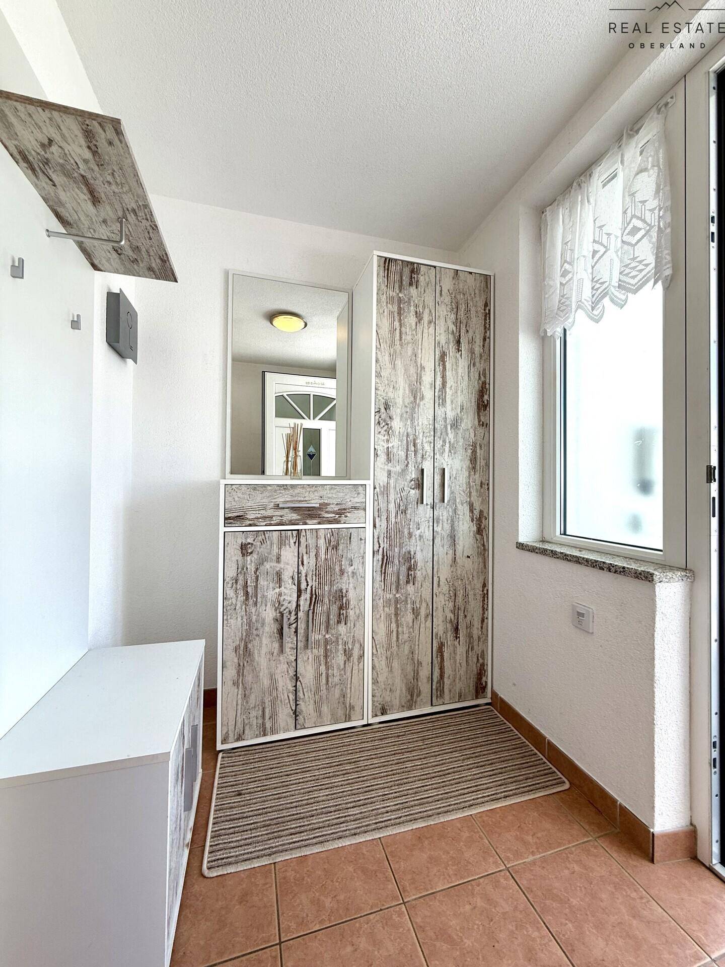 Eingangsbereich mit Garderobe, Spiegel und Fliesenboden, bietet praktischen Stauraum.