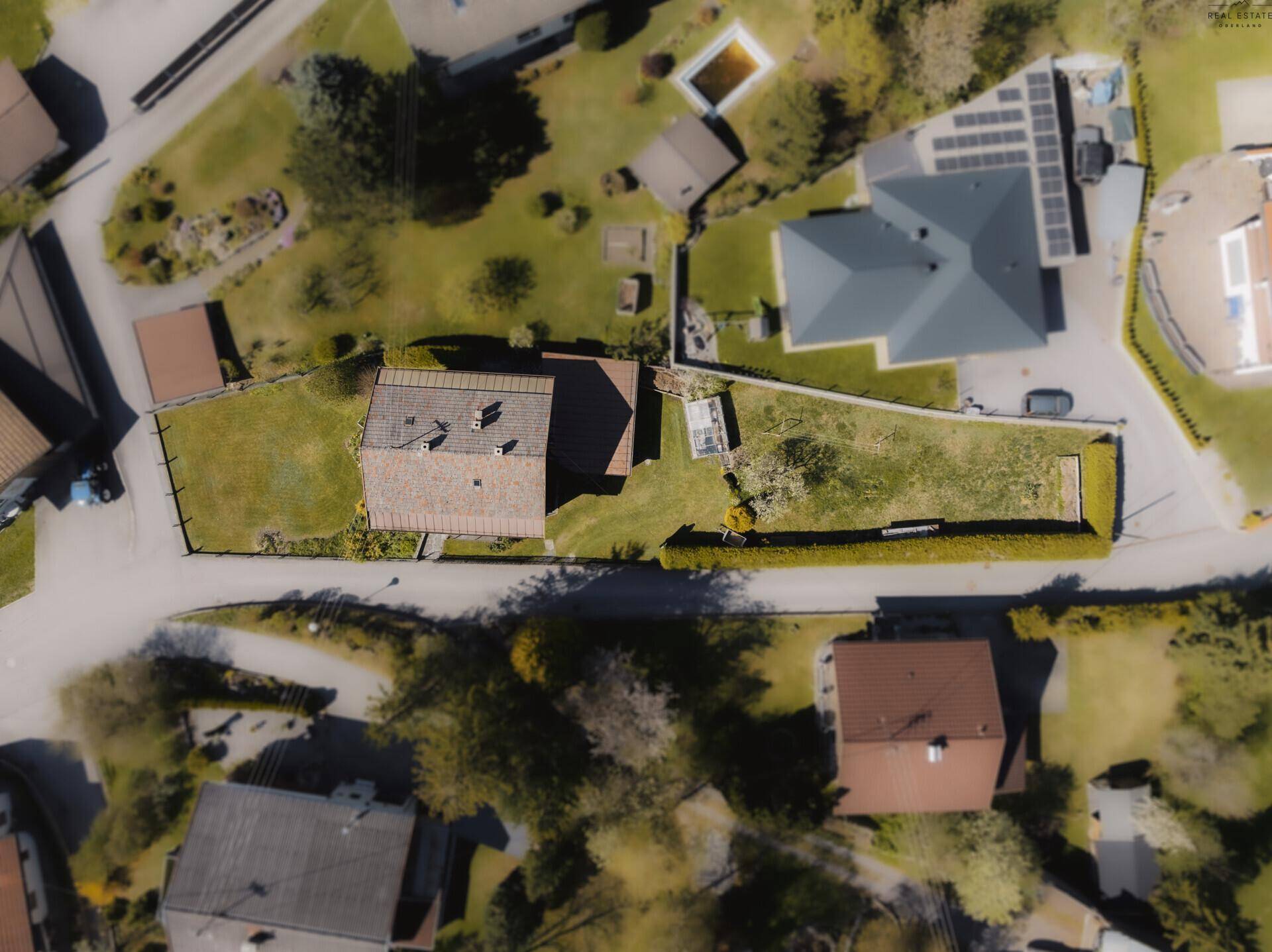 Luftaufnahme des Grundstücks mit Haus, Garten und umliegender Bebauung.