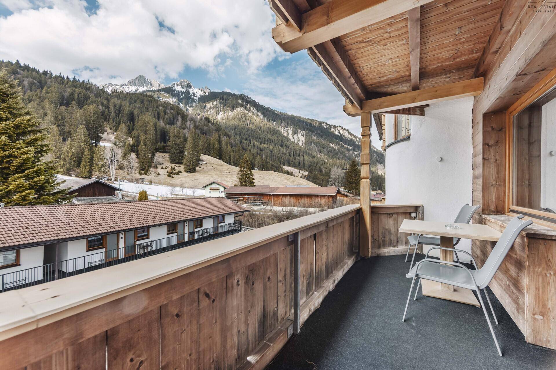 Balkon mit Sitzgelegenheiten und weitem Blick auf die umliegenden Berge und das Tal.