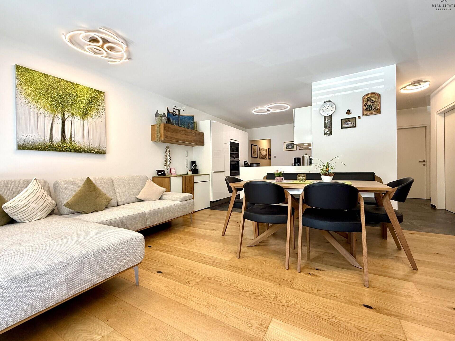 Gemütlicher Wohn-Essbereich mit Sofa, Esstisch und moderner Kunst an der Wand.