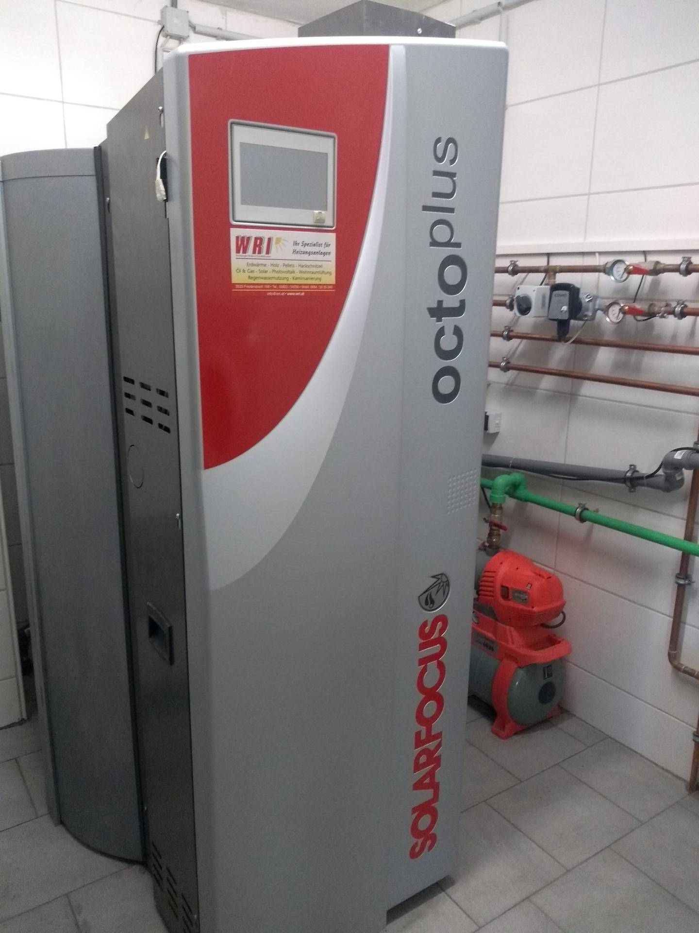 Heizungsraum mit moderner Pelletheizung und Warmwasserspeicher.