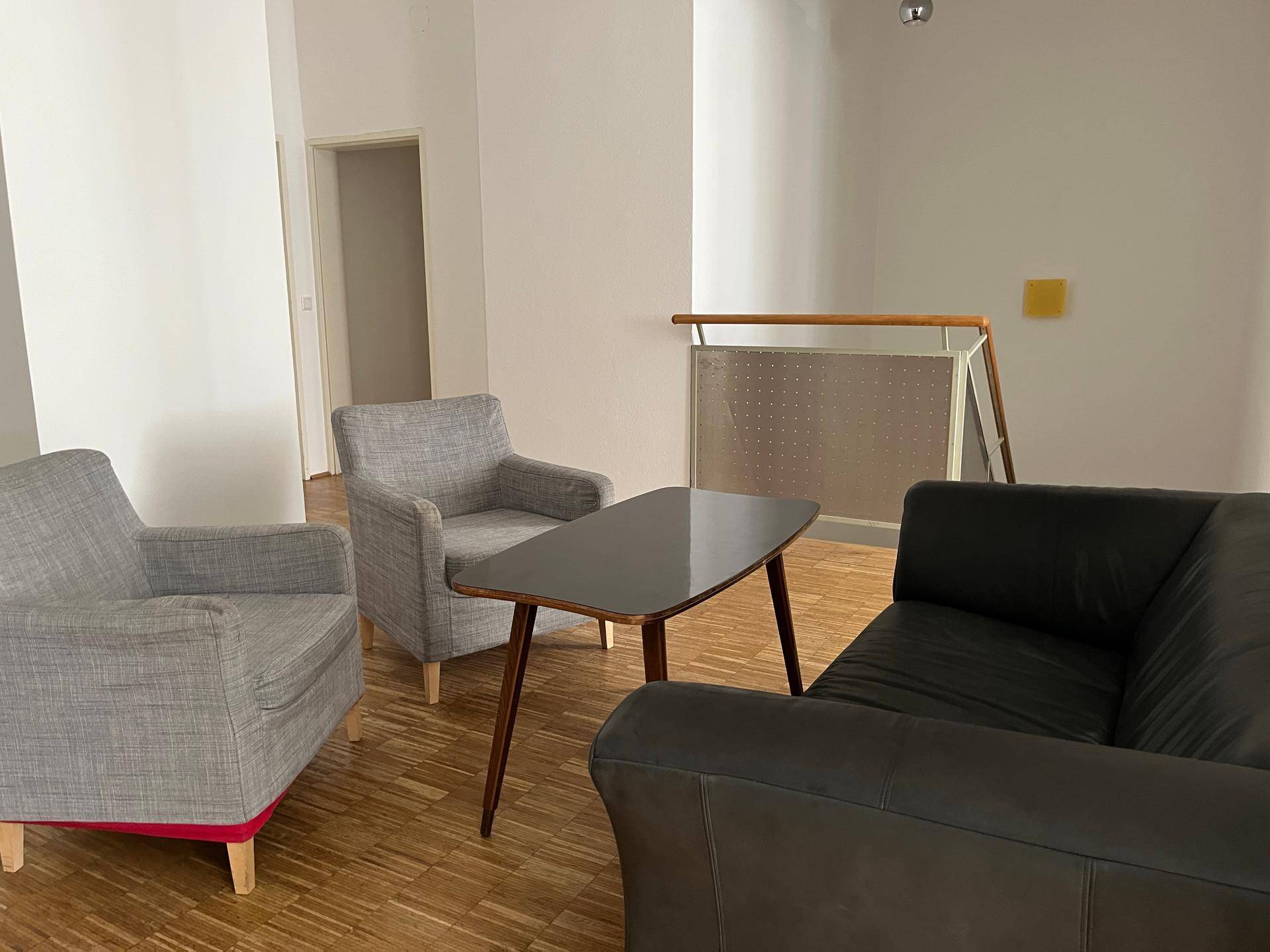 Gemütlicher Wohnbereich mit Sofa, Sesseln und einem stilvollen Couchtisch.