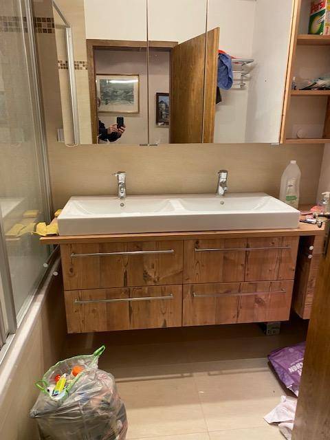 Modernes Badezimmer mit Doppelwaschbecken, Holzunterschrank und großem Spiegelschrank.