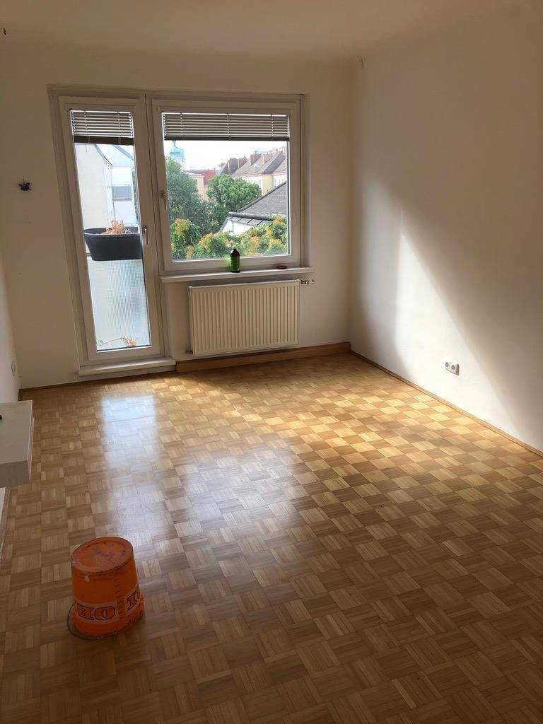 Helles Zimmer mit Parkettboden und Zugang zu einem französischen Balkon, ideal als Schlafzimmer.