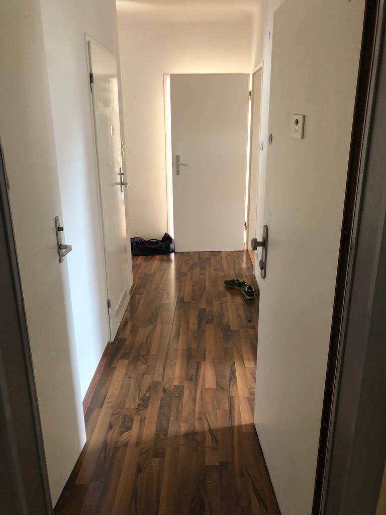 Heller Flur mit Laminatboden und mehreren Türen, die zu den angrenzenden Räumen führen.