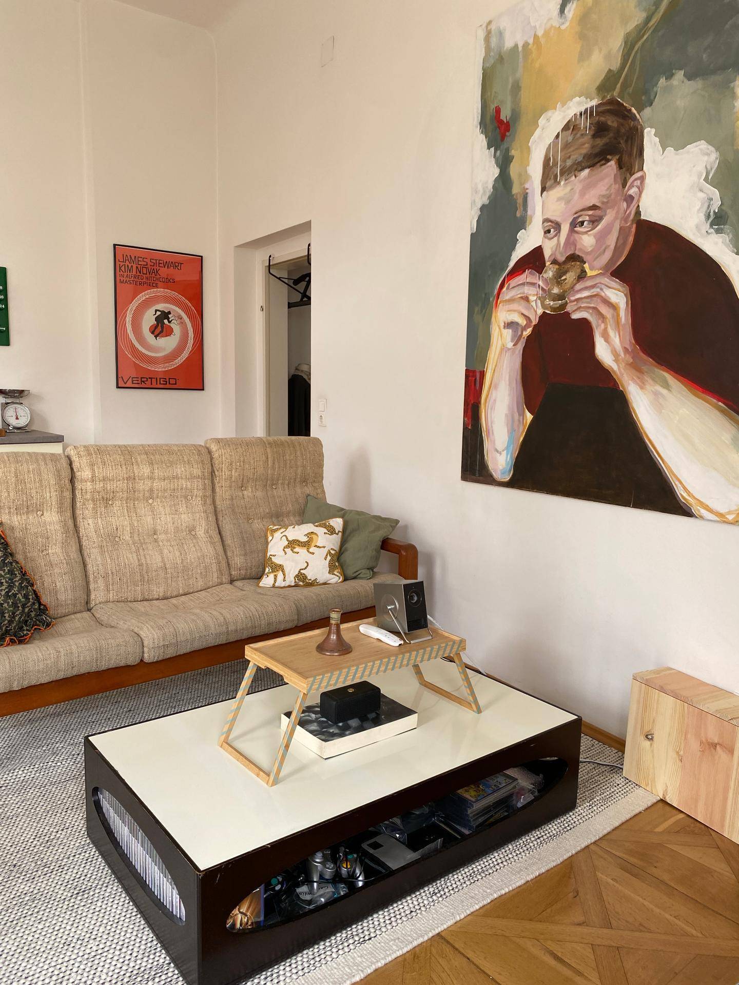 Gemütlicher Wohnbereich mit Sofa, Couchtisch und einem auffälligen Kunstwerk an der Wand.