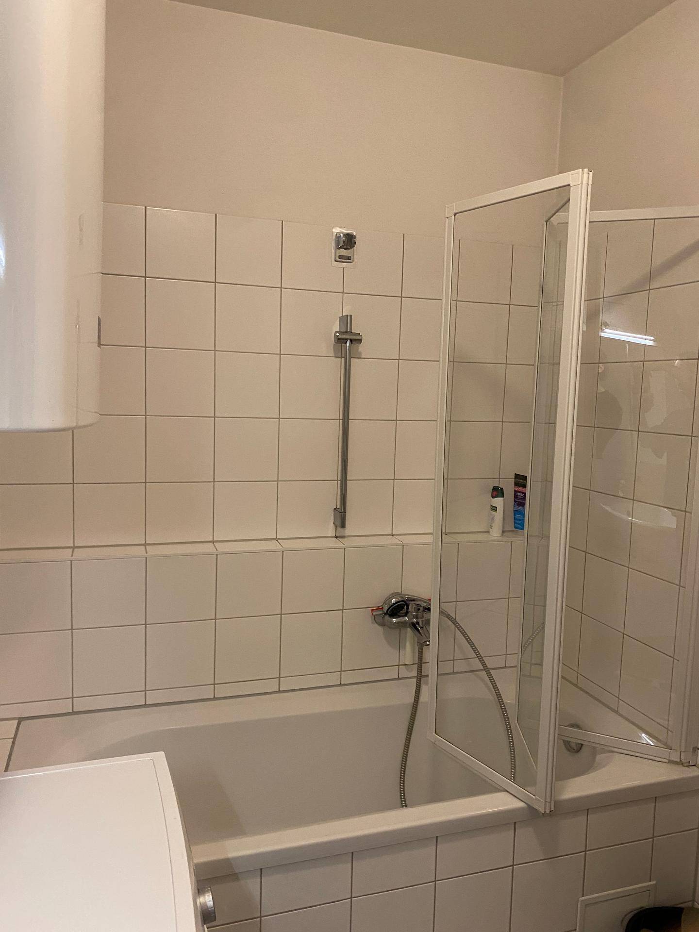 Badezimmer mit Badewanne und Duschwand, ideal für Entspannung und Hygiene.