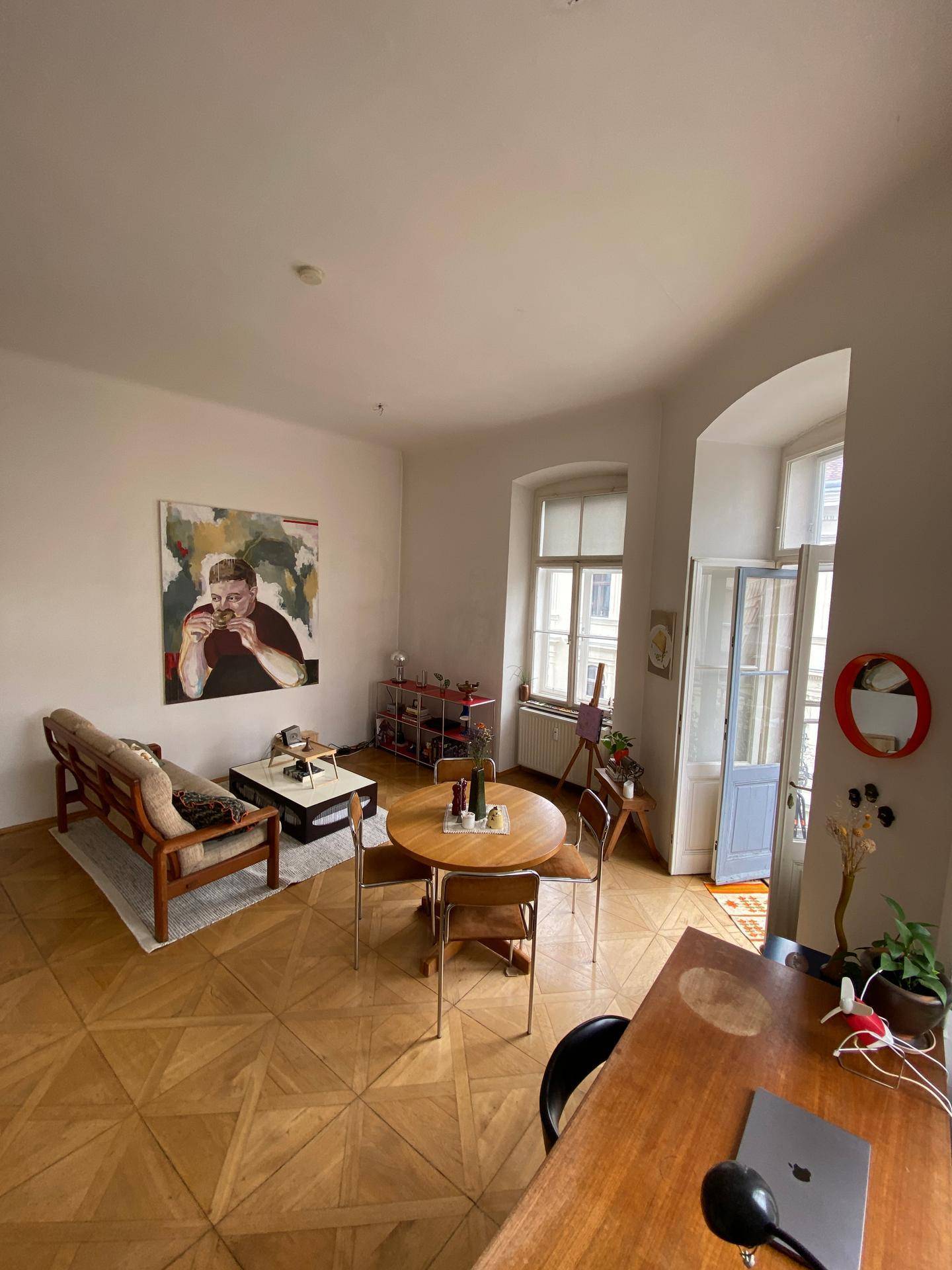 Geräumiger Wohn-Essbereich mit Holzboden, Esstisch und einem großen Kunstwerk an der Wand.