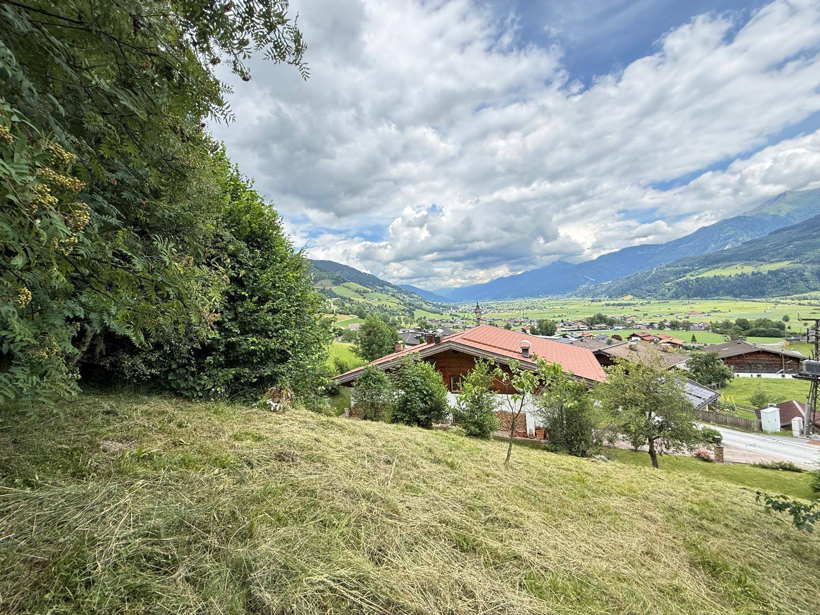 Panoramablick auf ein charmantes Haus in den Alpen, umgeben von üppiger Natur und Bergen.