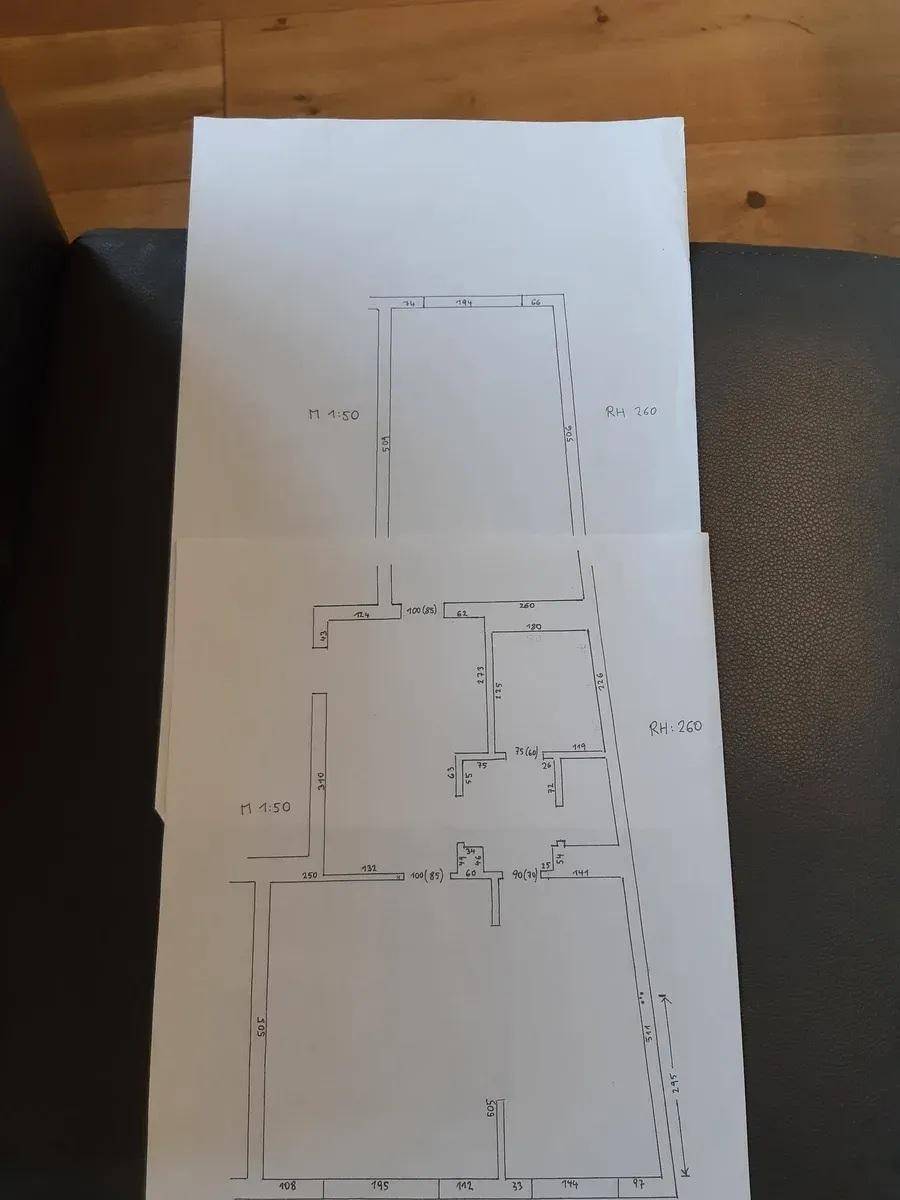 Handgezeichneter Grundriss mit Raumaufteilung und Maßen, der Dachschrägen andeutet.