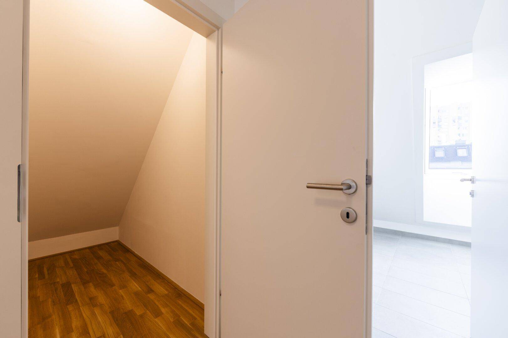 Praktischer Abstellraum mit Parkettboden und Dachschräge, ideal für zusätzlichen Stauraum.