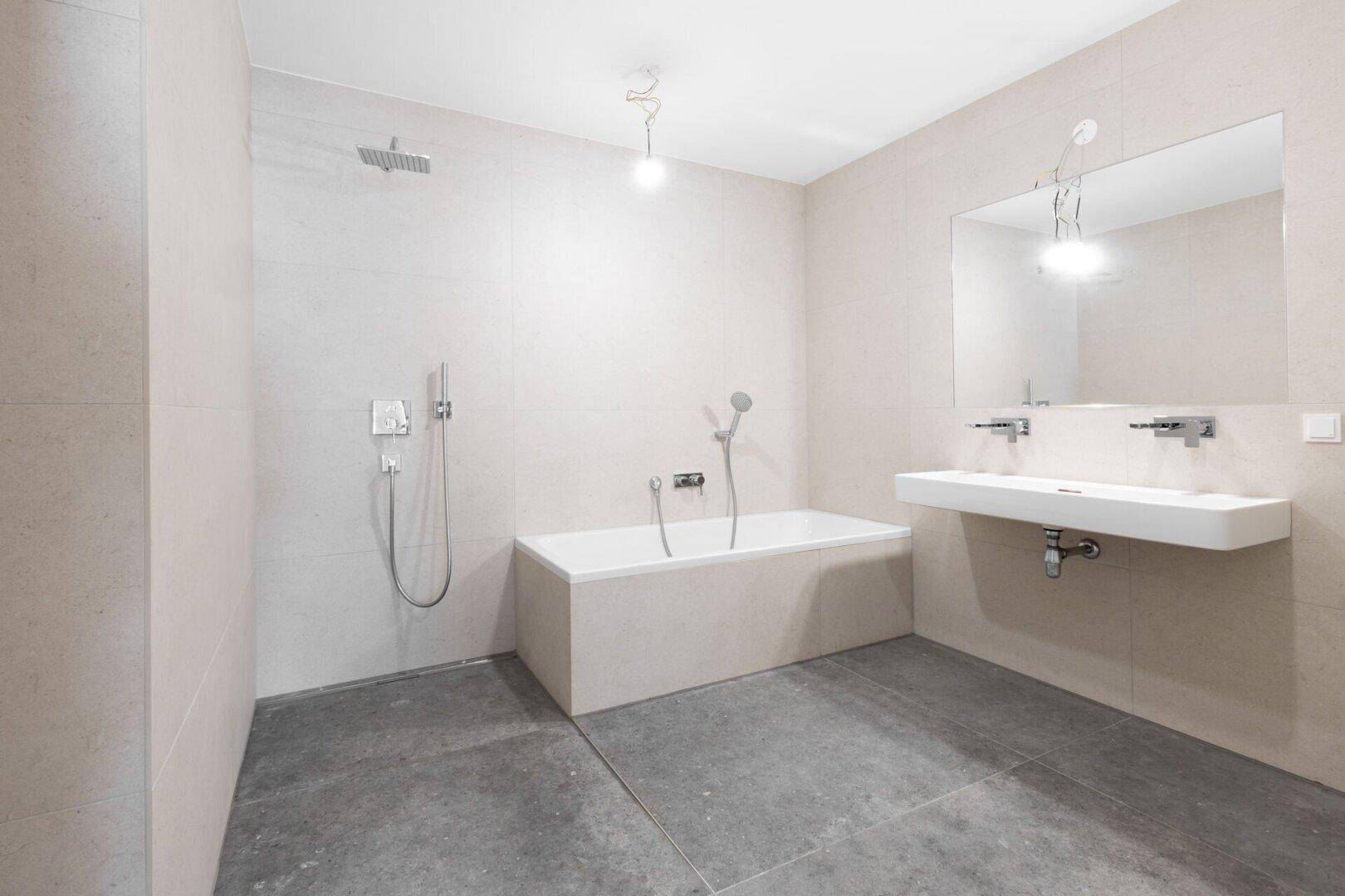 Geräumiges Badezimmer mit Badewanne, Dusche und Doppelwaschbecken.