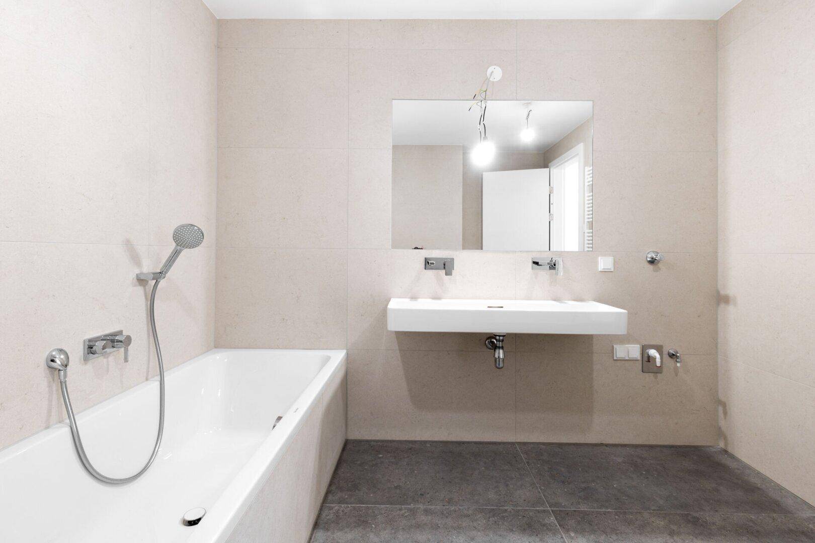 Helles Badezimmer mit Badewanne, Dusche und Doppelwaschbecken.