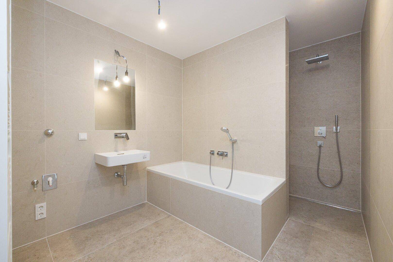 Modernes Badezimmer mit beigefarbenen Fliesen, Badewanne und ebenerdiger Dusche.