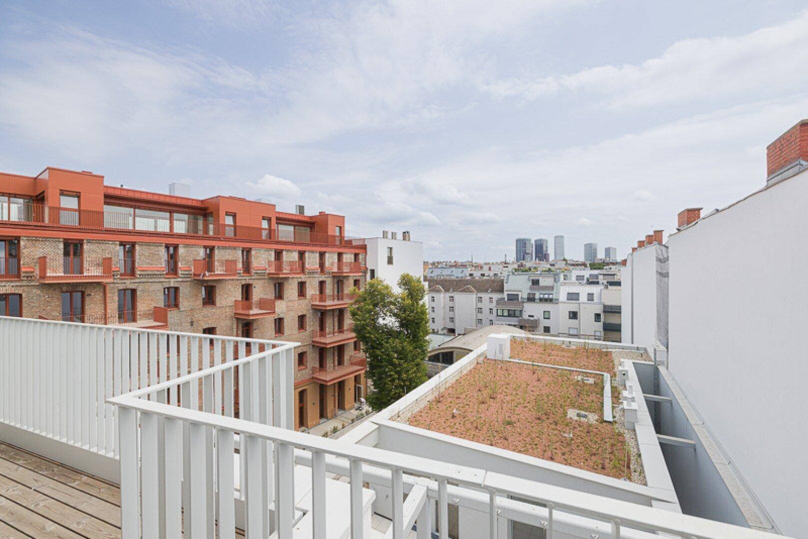 Weitläufige Dachterrasse mit Holzboden und Panoramablick über die Stadt.