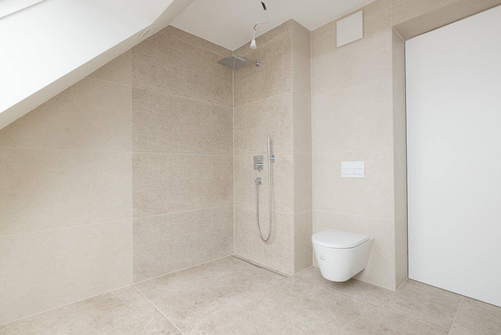 Modernes Badezimmer im Dachgeschoss mit ebenerdiger Dusche und wandhängendem WC.