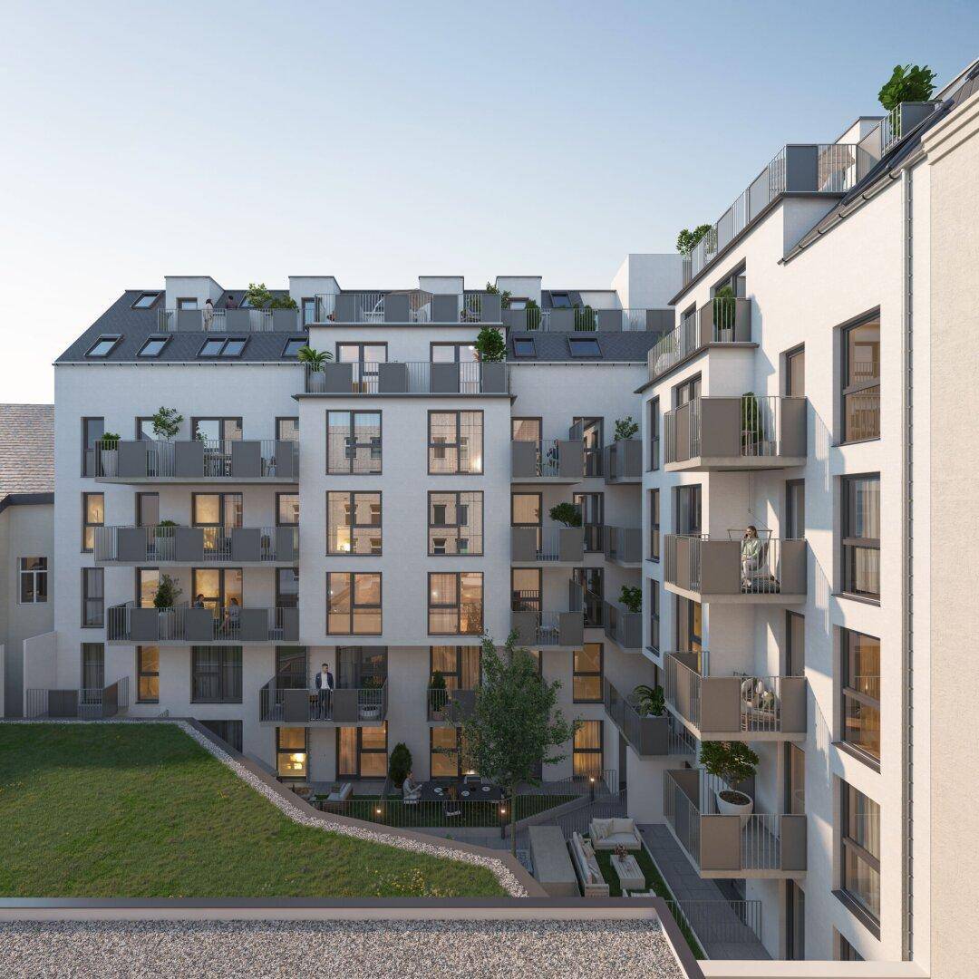 Ansicht der modernen Gebäudefassade mit zahlreichen Balkonen und Dachterrassen, umgeben von Grünflächen.