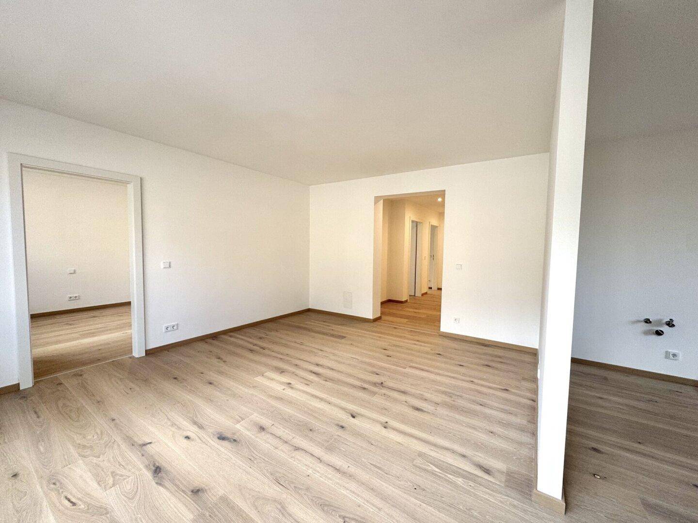 Heller Flur mit Parkettboden, der zu verschiedenen Zimmern der Wohnung führt.