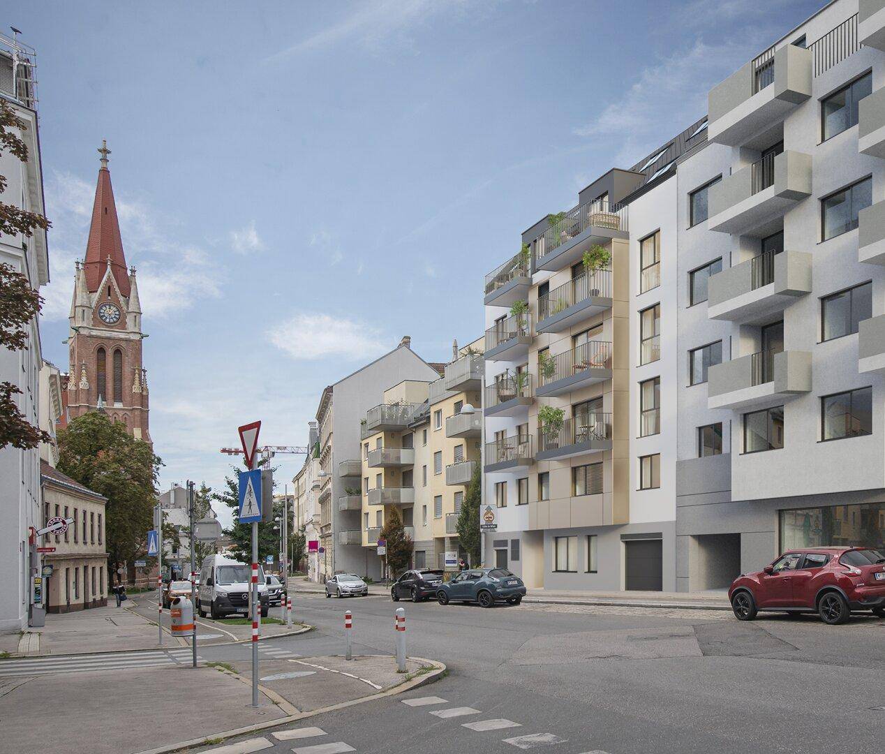 Moderne Wohngebäude an einer Stadtstraße mit Balkonen und einem Kirchturm im Hintergrund.