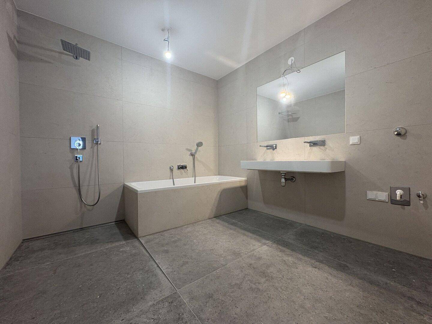 Modernes Badezimmer mit Badewanne, Regendusche und Doppelwaschbecken.