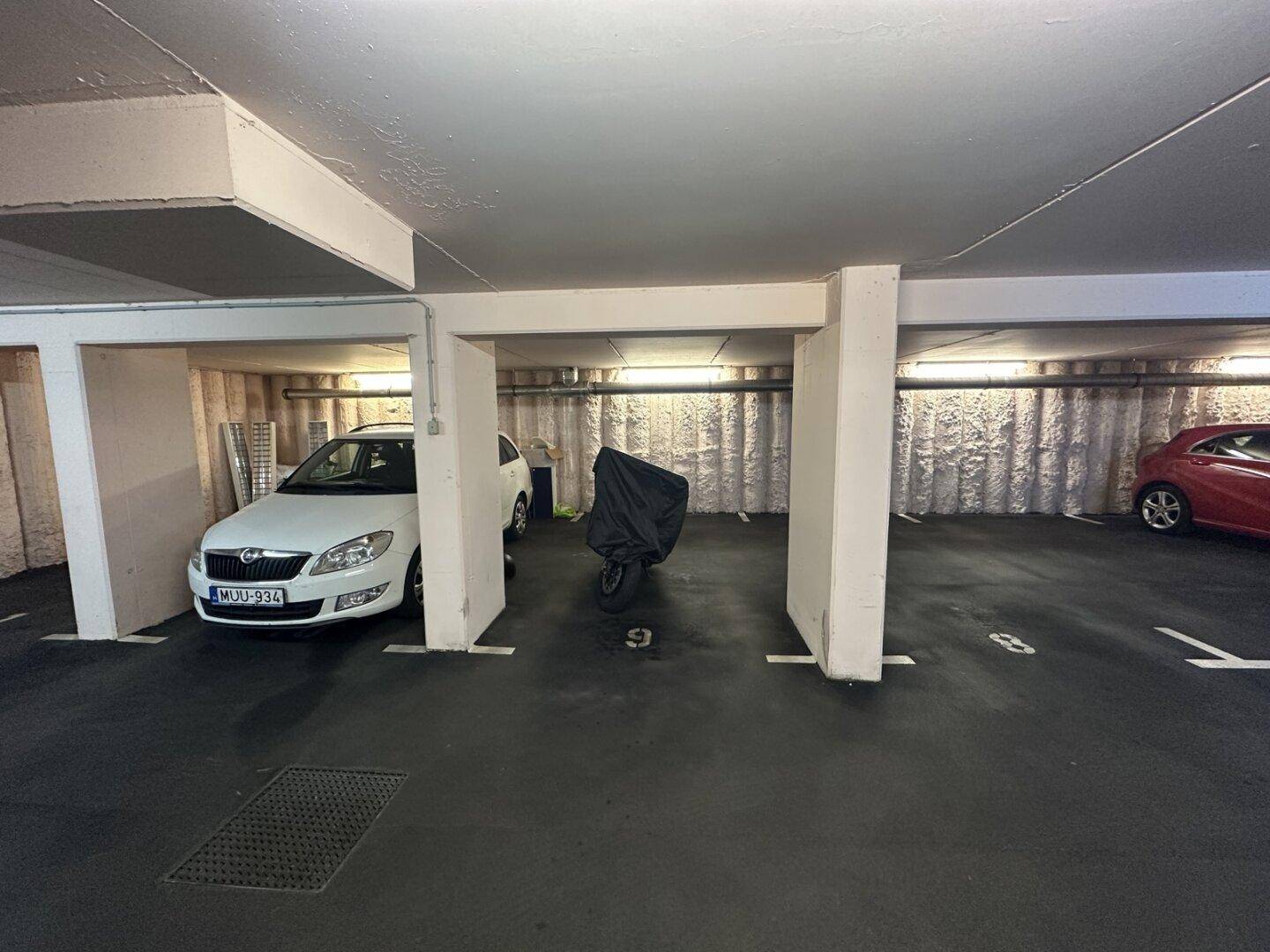 Übersicht der Tiefgarage mit mehreren Fahrzeugen und klar markierten Parkflächen.