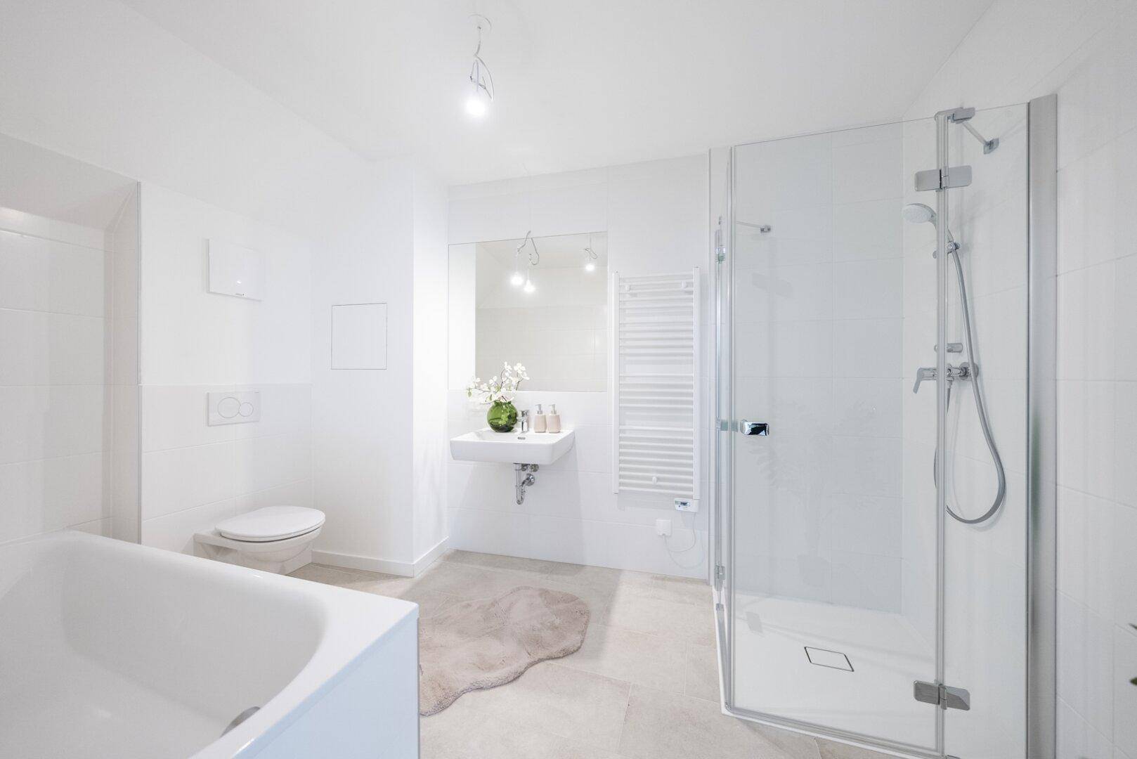 Geräumiges Badezimmer mit Badewanne, Duschkabine, Waschbecken und modernen Armaturen.