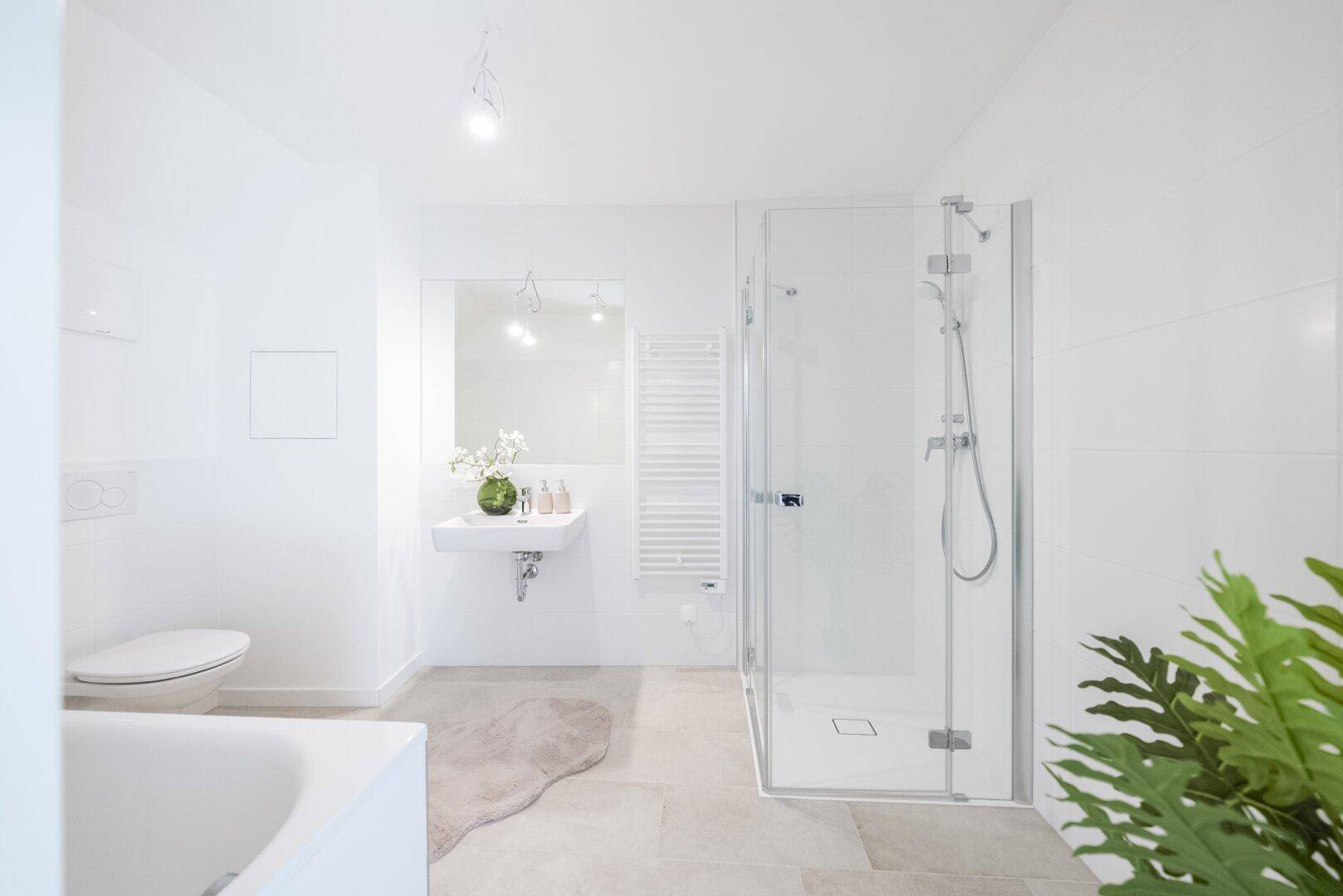 Modernes Badezimmer mit Badewanne, Duschkabine, Waschbecken und beheiztem Handtuchhalter.