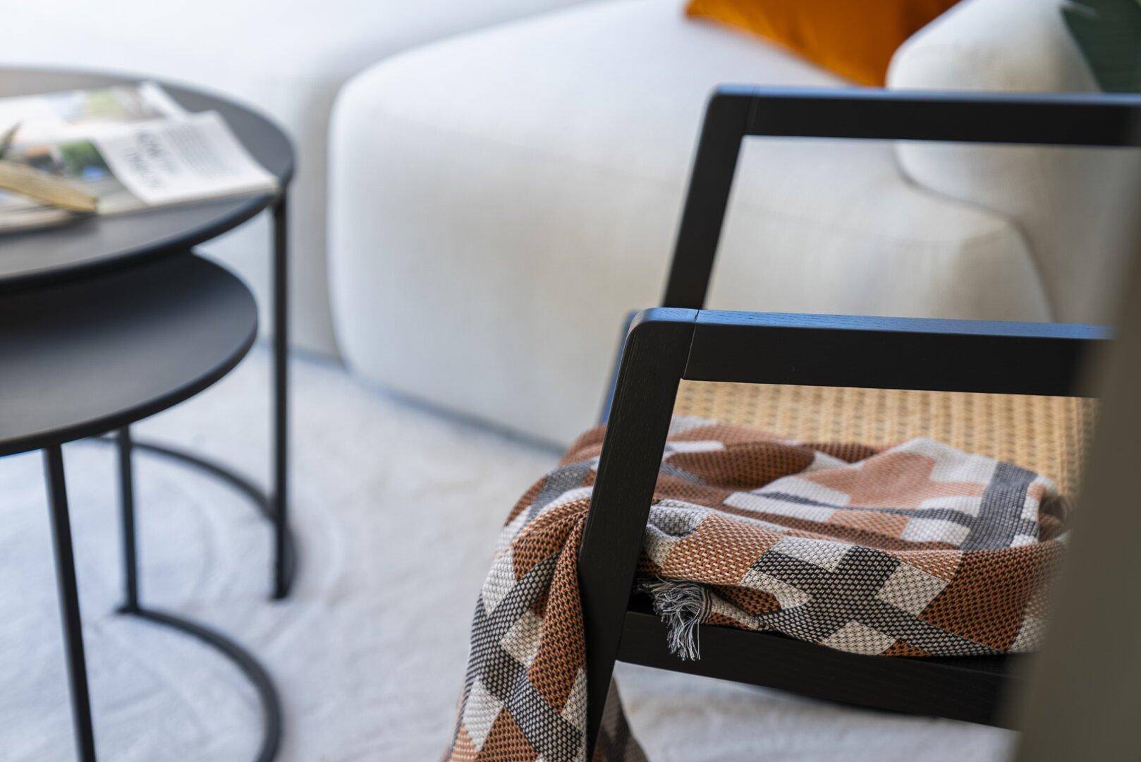Detailaufnahme eines modernen Wohnzimmers mit bequemer Couch und stilvollen Beistelltischen.