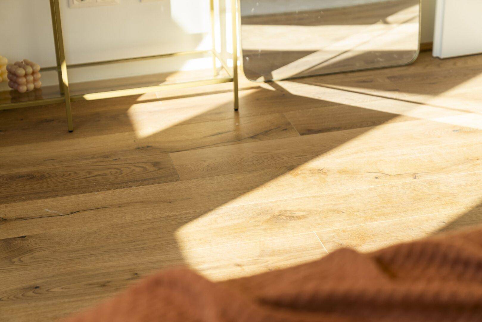 Sonnenlicht fällt auf den Holzboden eines Raumes und schafft warme Lichteffekte.