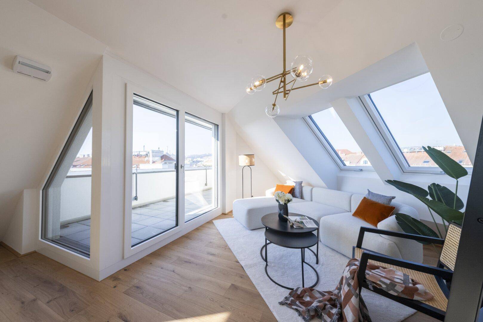 Lichtdurchflutetes Wohnzimmer mit moderner Einrichtung und direktem Zugang zur Dachterrasse.