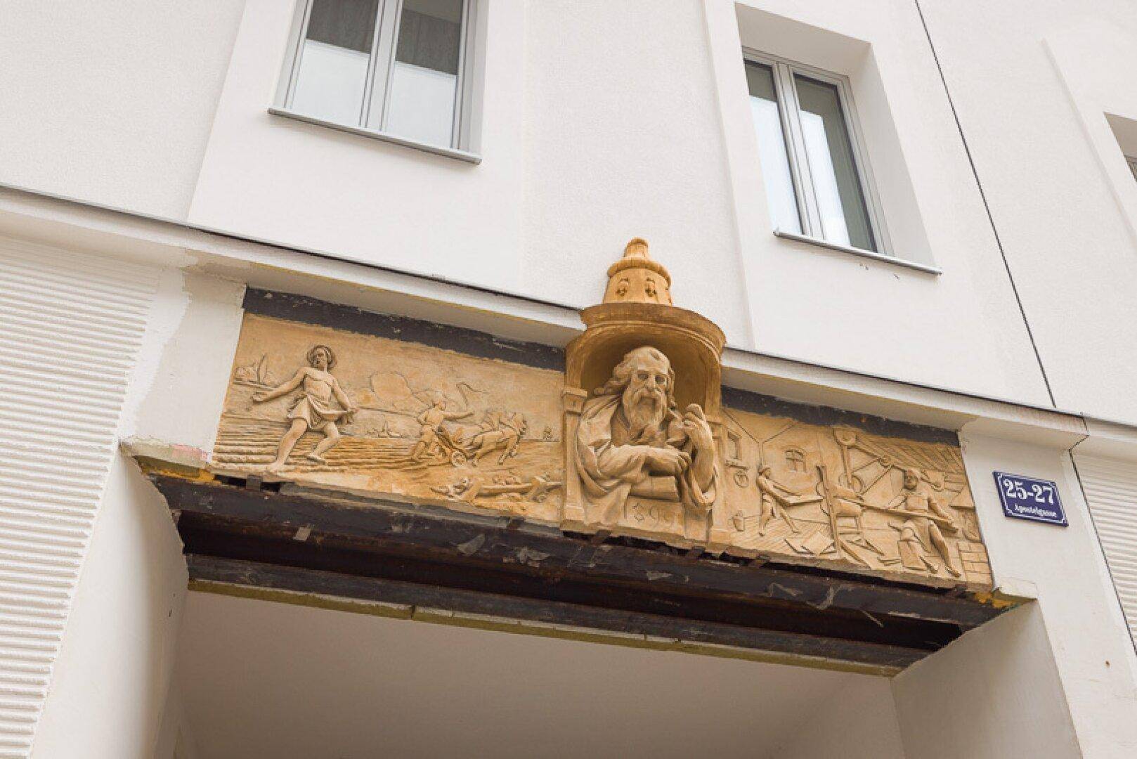 Historisches Relief über einem Durchgang mit der Hausnummer 25-27.
