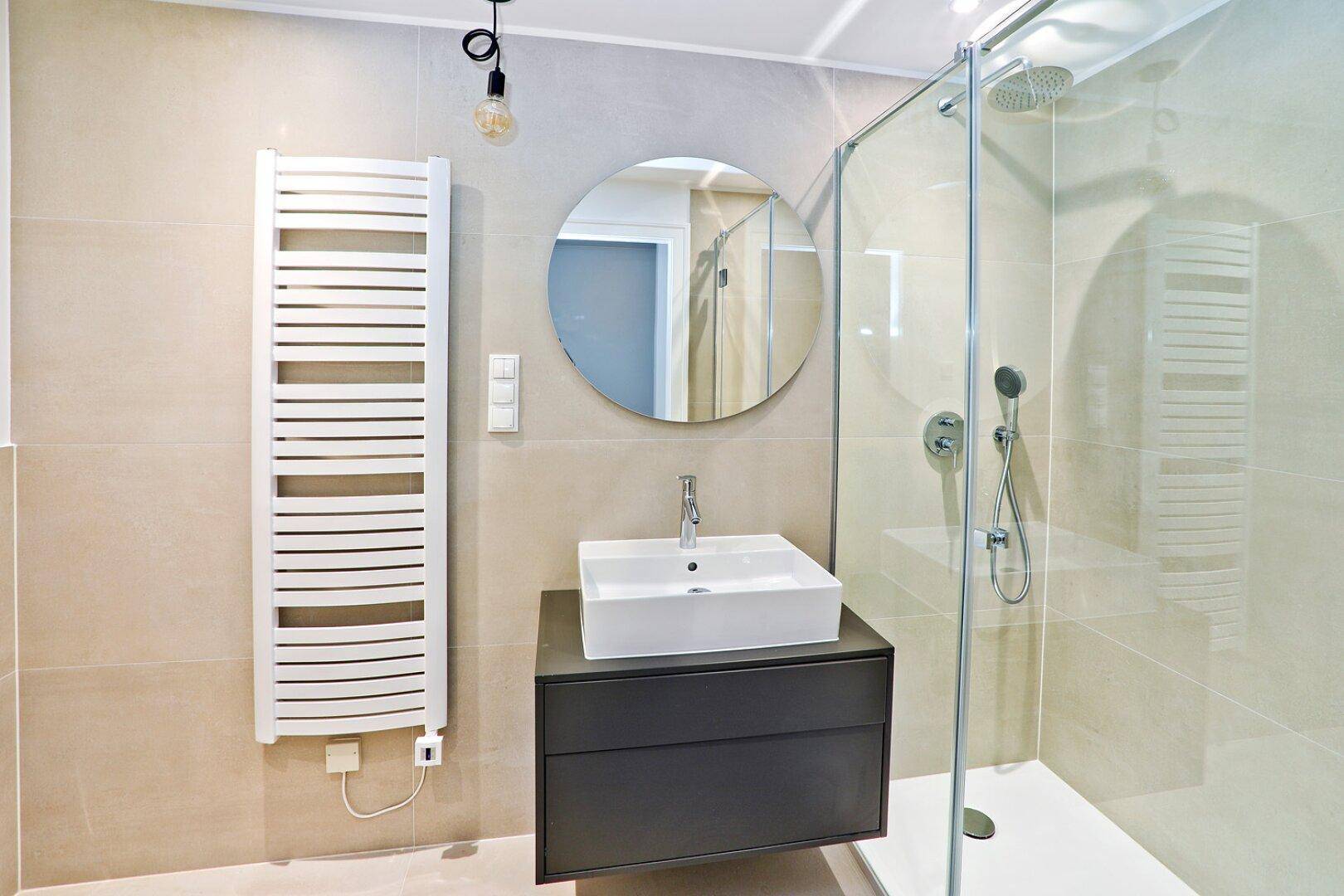 Modernes Badezimmer mit begehbarer Dusche, Einzelwaschbecken und Handtuchheizkörper.