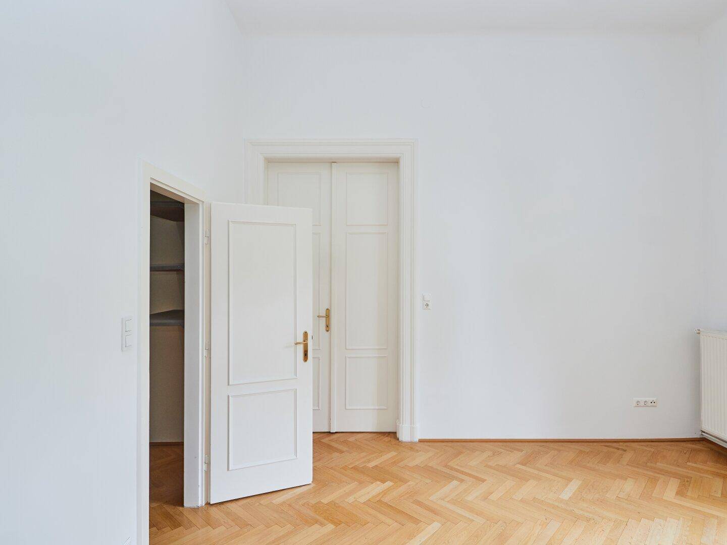 Kleiner Abstellraum mit Regalsystem und Fischgrätparkett, ideal für zusätzlichen Stauraum.