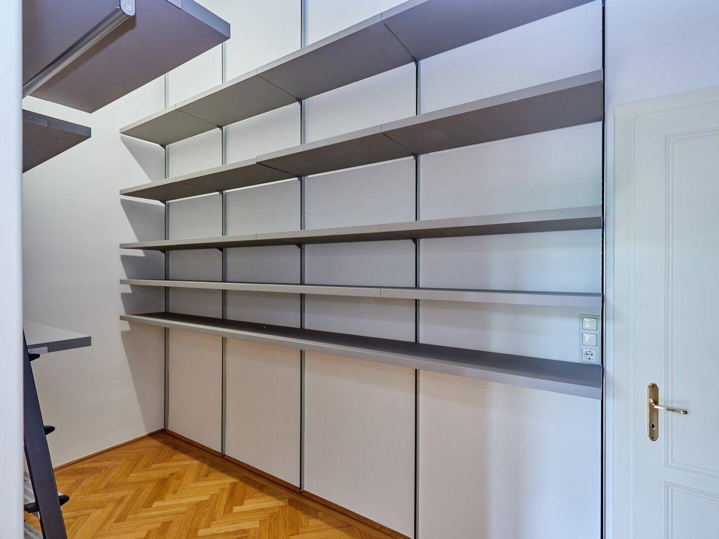 Praktischer Abstellraum mit offenen Regalen und Schränken, perfekt für Organisation.